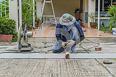 asian worker with machine cutting metal and welded steel to create a roof, local labor construction concept Stock Photo