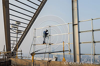 Asian worker weld on top of high building without scaffolding, low safety working condition Stock Photo