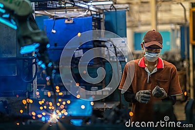 Asian worker working in old chinese factory in robot auto welding machine section Stock Photo