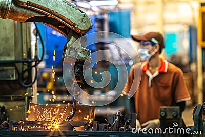 Asian worker working in old chinese factory in robot auto welding machine section Stock Photo