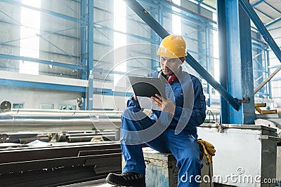 Asian worker writing observations about manufacturing Stock Photo