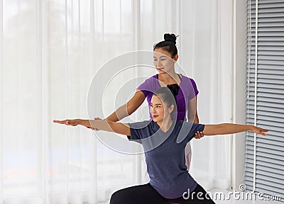 Asian yoga teachers teach students one-on-one in gym to be healthy and strong Stock Photo