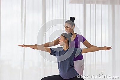 Asian yoga teachers teach students one-on-one in the gym. Stock Photo