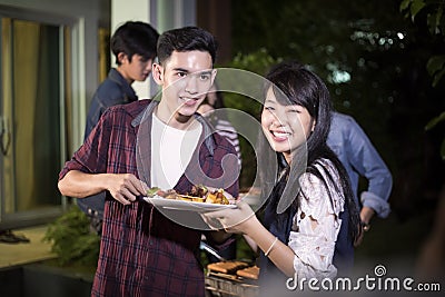 Asian young couple enjoying a romantic dinner and group of frie Stock Photo