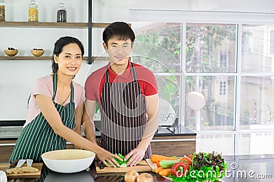 Asian young couple. Are standing smiling cooking in the kitchen at home. Stock Photo