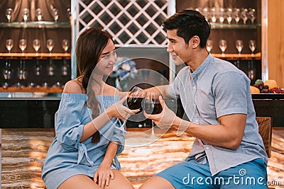 Asian young couples clinking wine glasses at domestic bar of lux Stock Photo