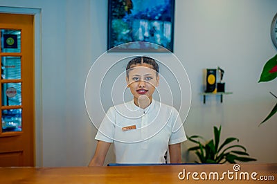 Asian young female receptionist working on duty at the tropical resort Editorial Stock Photo