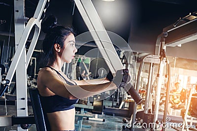 Asian young fitness woman execute exercise with exercise-machine in gym Stock Photo