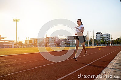 Asian Young fitness woman runner running on stadium track -healthy lifestyle and sport concepts Stock Photo