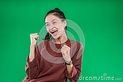 Asian young girl expressing face happiness with clenched into fists and raised two hands Stock Photo