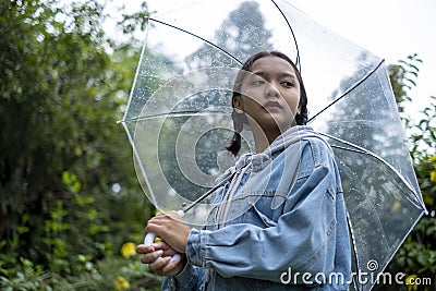 Asian young girl wear jean coat in rain Stock Photo