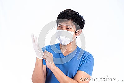 Asian young man in blue t-shirt top with medical mask and latex gloves to protect COVID-19 with isolated on white background Stock Photo