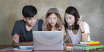 Asian young man and woman sitting pointing studying examining Stock Photo