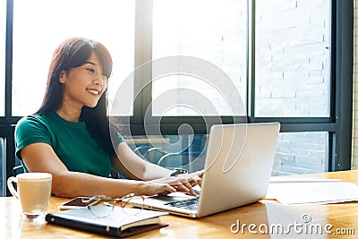 Asian young owner business woman working online, checking mail on laptop organizing working process in office. Copy space. Stock Photo