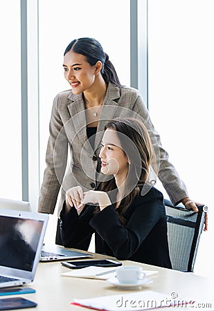 Asian young professional successful businesswoman employee colleagues in formal suit sitting standing in meeting room, typing Stock Photo