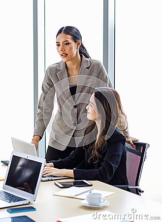 Asian young professional successful businesswoman employee colleagues in formal suit sitting standing in meeting room, typing Stock Photo