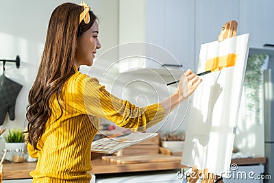 Asian young talented woman artist coloring on painting board in house. Attractive beautiful female draw art picture, creating Stock Photo