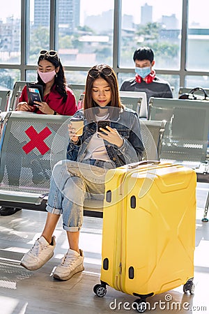 Asian girl using phone at airport departure waiting seat Stock Photo