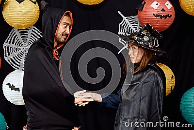 Asian young wizard Halloween man portrait standing with witch Halloween woman shaking hand Stock Photo