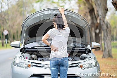 Asian young woman opened the hood Broken car on the side See engines that are damaged or not. Broken down car while traveling Stock Photo