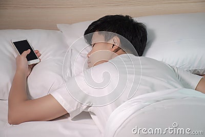 Asians sleep while the smartphone is on their hands Stock Photo