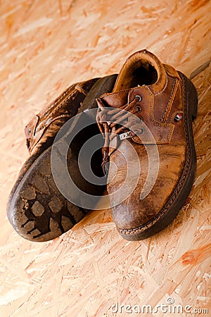 Askew photo of old brown leather shoes on OSB board Stock Photo