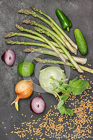 Asparagus, cucumbers, lime and kohlrabi, onions and red lentils on table Stock Photo