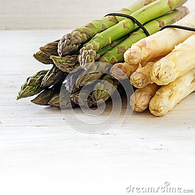 Asparagus, green and white bunch on bright painted wood, background with copy space fades to white, close up Stock Photo