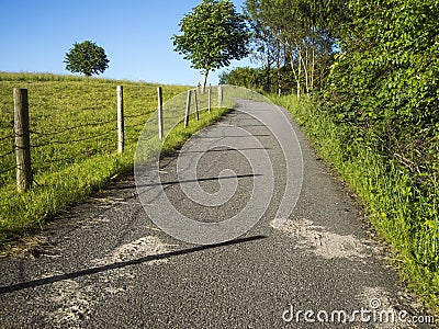 Asphalt agricultural road uphill blue sky Stock Photo