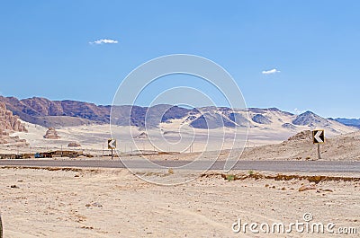 Asphalt motorway built in large desert with rocky mountains Stock Photo