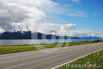 Asphalt road along the blue fjord. Stock Photo