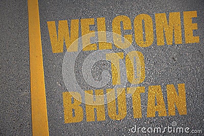 asphalt road with text welcome to bhutan near yellow line. Stock Photo