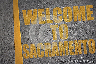 asphalt road with text welcome to Sacramento near yellow line Stock Photo