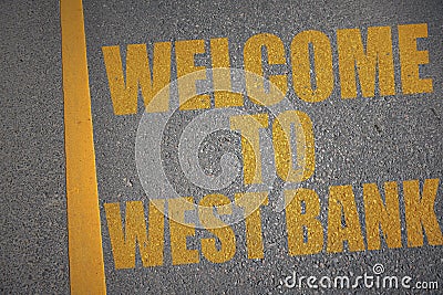 asphalt road with text welcome to West bank near yellow line Stock Photo