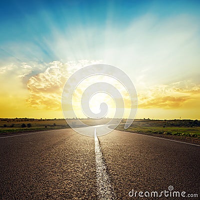 Asphalt road to horizon and sunset in clouds Stock Photo