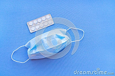 Aspirin in a blister medical dressing. White tablets in a blister on a blue background close-up with soft focus. Stock Photo