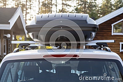 Assembled and closed, roomy trunk or cargo box on the roof of the car, in the yard. Rear view. Stock Photo