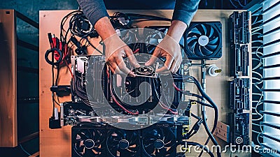 Hands assembling a blockchain mining rig with hardware components Stock Photo