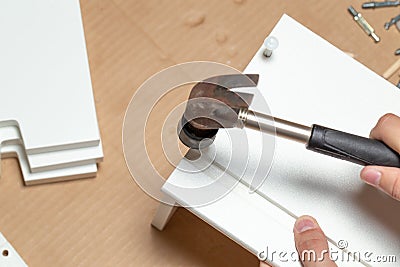 Assembling of furniture, closeup of hammer in hand Stock Photo