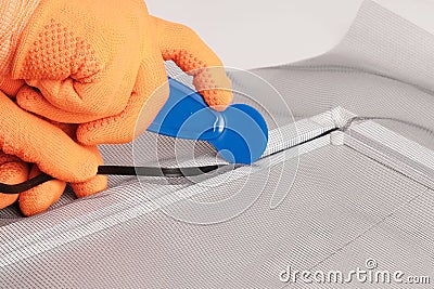 Assembling mosquito net for window, installing seal in an aluminum profile Stock Photo