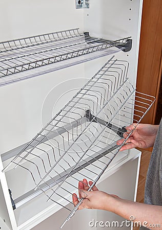 Assembly wire dish rack for drying dishes inside kitchen cabinet Stock Photo