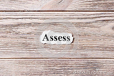 ASSESS of the word on paper. concept. Words of ASSESS on a wooden background Stock Photo