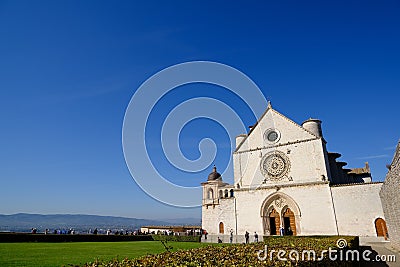 Church of San Francesco in Assisi with the stone wall. The basilica built in Gothic style houses the frescoes by Giotto Editorial Stock Photo