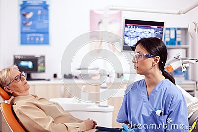 Assistant in dentist cabinet during elderly woman oral hygiene check up Stock Photo