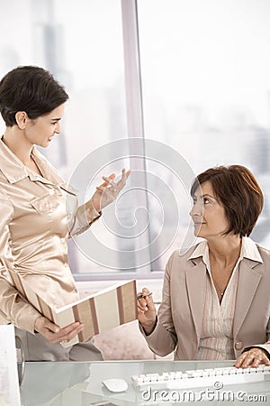 Assistant showing documents to businesswoman Stock Photo