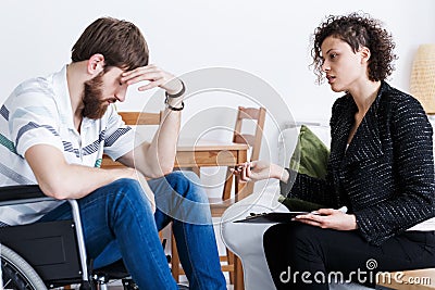 Assistant talking with invalid patient Stock Photo