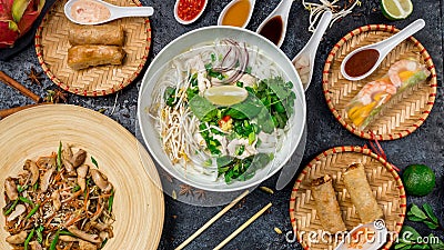 Assorted asian dinner, vietnamese food. Pho ga, pho bo, noodles, spring rolls Stock Photo