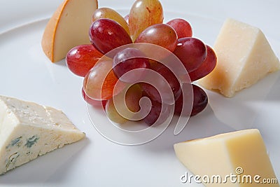 Assorted cheeses and grape on a white plate Stock Photo