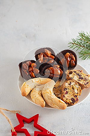 Assorted Christmas cookies and sweets on a round plate on a light concrete background in Christmas style. Merry Christmas concept Stock Photo