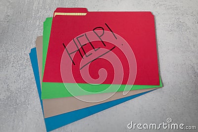 Assorted color file folders fanned out filing office materials and supplies Help handwritten on red file Stock Photo